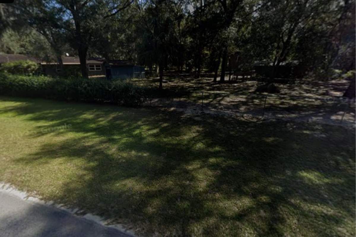 Well maintained home and shaded yard across from land for sale on Holiday Drive in Interlachen FL